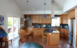 The kitchen in this home gets extra light from the abundant windows in the adjacent living room’s east-facing wall. Sliders (at left) lead outside to a covered deck