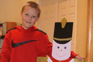 Ethan Riker, 9, gets better acquainted with a toy soldier that welcomes guests to the Oak Harbor Main Street office on Pioneer Way in Oak Harbor. The organization placed 34 of the soldiers up for adoption, asking community members and businesses to decorate them for public display downtown later this month. This one was painted by Whidbey Island artist Margaret Livermore. Photo by Ron Newberry/Whidbey News-Times