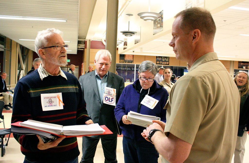 File photo                                Michael Monson, who was then president of Citizens of Ebey&rsquo;s Reserve, speaks with Capt. Michael Nortier, then-commanding officer of Naval Air Station Whidbey Island, during a 2013 scoping meeting on the Growler Environmental Impact Statement.