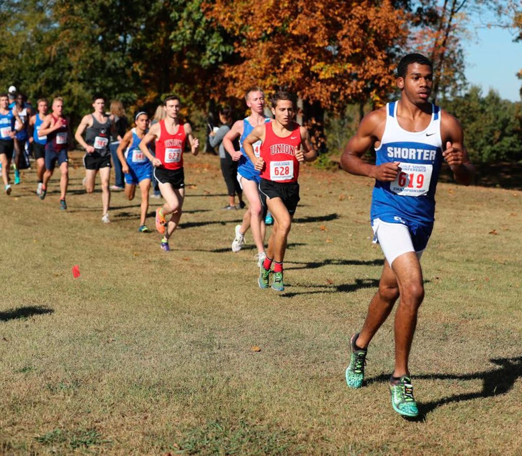 Dejon Devroe, right, runs to 17th place in his conference championship meet. (Photo by Charles Edgeworth)