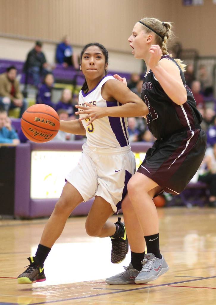 Oak Harbor&rsquo;s Rashanna Graham tries to drive by Lakewood&rsquo;s Jenna Langdon. (Photo by John Fisken)