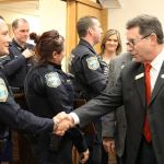 Photo by Jessie Stensland/Whidbey News-Times                                Oak Harbor Mayor Bob Severns shakes hands with Officer Michael Brown, who was recognized Tuesday for helping to catch the Cascade Mall shooting suspect. The mayor and council members also thanked Officer Mike Clements and Officer Claire Schricker for saving a man who was in a medical crisis.