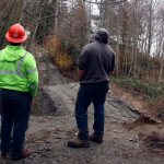 Workers survey a section of Driftwood Way that was destroyed in the 2013 landslide. The county budgeted to fix the road next year.