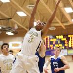 Justin Ellison snares a rebound for Oak Harbor. (Photo by John Fisken)