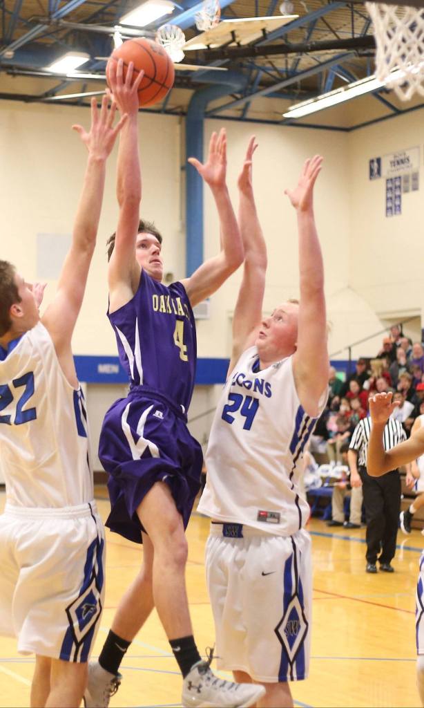 Wildcat Gabe Salinger splits Falcon defenders Anton Klein (22) and Tyler Dow (24) for two points. (Photo by John Fisken)
