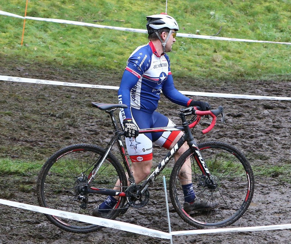 John Clark finds it easier to carry his bike than to ride in this muddy section of the course. (Photo by John Fisken)