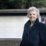 Arlene House of Coupeville stands before her garage that she also uses as a classroom as a life coach and tutor. Central Whidbey Hearts & Hammers has done multiple projects at her home, including replacing the garage door and roof. Photo by Ron Newberry/Whidbey News-Times