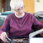 Jean Shaw, a Langley resident and retired teacher, looks through her lifelong scrapbook, &ldquo;Bits & Pieces: 75 Years of Random Memories.&rdquo; Shaw is considered an instrumental piece to the development of drama amongst youth on South Whidbey. Photo by Evan Thompson/Whidbey News Group