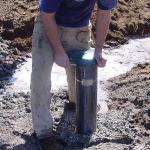 A well driller works on the end cap of a well just finished. As a result of a Supreme Court decision last fall, management of groundwater withdrawals are in turmoil as counties now left with the task are unable to determine how well systems affect nearby rivers and those already with operating wells. Rural landowners are being denied building permits as a result.                                &mdash; Photo courtesy of Department of Ecology