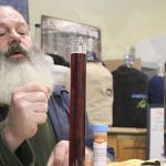 Terry Boese checks how a batch of elderberry wine is aging at his Oak Harbor store, Whidbey Island Homebrew Supply.                                Photo by Patricia Guthrie/Whidbey News-Times