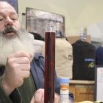Terry Boese checks how a batch of elderberry wine is aging at his Oak Harbor store, Whidbey Island Homebrew Supply.                                Photo by Patricia Guthrie/Whidbey News-Times