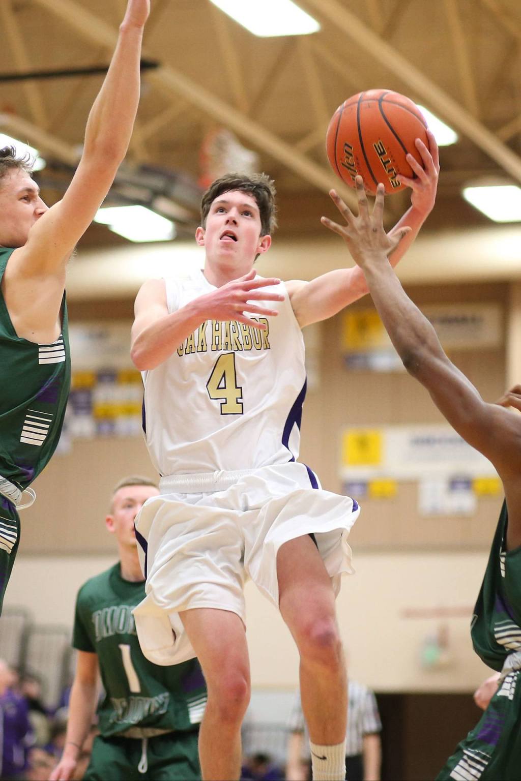 Gabe Salinger goes to the hoop for Oak Harbor. (Photo by John Fisken)