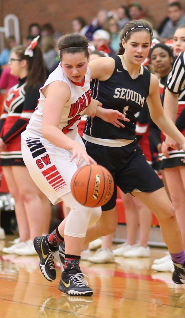 Mia Littlejohn slips by Sequim&rsquo;s Hope Glasser in Monday&rsquo;s win. Littlejohn&rsquo;s strong all-around game helped the Wolves claim the non-league victory. (Photo by John Fisken)
