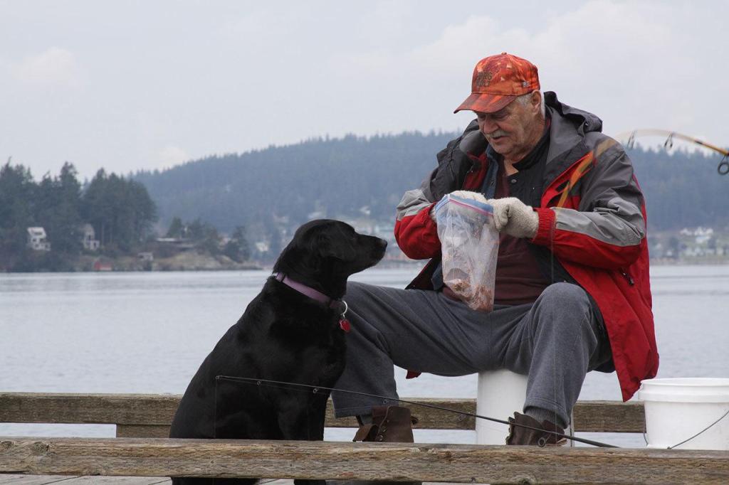 Dean Bannister tries a chum concoction to attract smelt but it also tends to get the attention of Molly, a labrador, Wednesday, Jan. 25, 2017. Photo by Ron Newberry/Whidbey News-Times