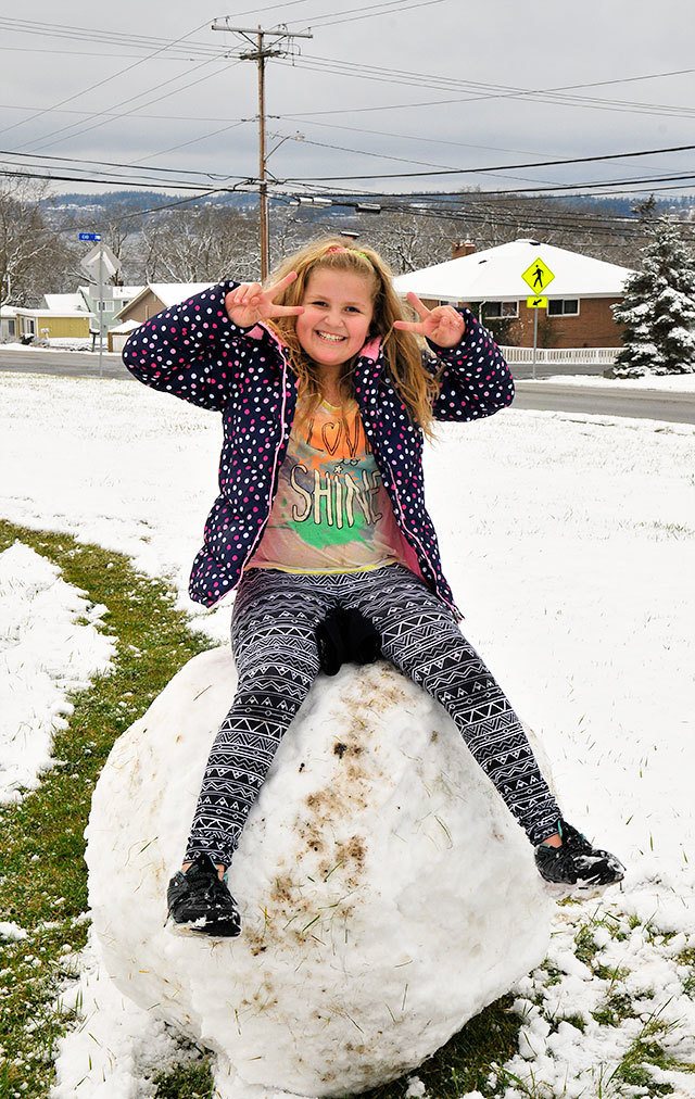 Alexis Black sits on a giant snowball in Oak Harbor, making the most out of the accumulated snow Monday. See more snow day photos on page 20 of today&rsquo;s Whidbey News-Times.