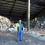 Todd Davis, lead technician at Island County&rsquo;s Solid Waste Facility near Coupeville, stands in front of record heaps of garbage that normally is cleared out daily. It piled up because of a paralyzing ice storm in southcentral Washington last month. Photo by Patricia Guthrie/Whidbey News-Times