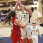 Oak Harbor&rsquo;s Samantha Hines and Mikhaela Cortez (21) sky for a rebound in Friday&rsquo;s game. (Photo by Jim Waller/Whidbey News-Times)