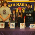 Sam Zook, left, Jennifer Turnek, Mary Johnston and Princeton Lollar all signed letters of intent this week to play college athletics. (Photo by Jim Waller/Whidbey News-Times)
