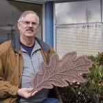 Skip Pohtilla, chairman of the Oak Harbor Arts Commission, shows a much smaller version of the sort of oak leaves that will be part of Oak Harbor&rsquo;s new public art piece Thursday, Feb. 23, 2017 in front of City Hall. The &ldquo;Autumn Leaves&rdquo; metal sculpture will show 10 leaves blowing in the wind. The sculpture will rest on the side of State Highway 20 near NE 4th Avenue. Photo by Ron Newberry/Whidbey News-Times