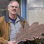 Skip Pohtilla, chairman of the Oak Harbor Arts Commission, shows a much smaller version of the sort of oak leaves that will be part of Oak Harbor&rsquo;s new public art piece Thursday, Feb. 23, 2017 in front of City Hall. The &ldquo;Autumn Leaves&rdquo; metal sculpture will show 10 leaves blowing in the wind. The sculpture will rest on the side of State Highway 20 near NE 4th Avenue. Photo by Ron Newberry/Whidbey News-Times