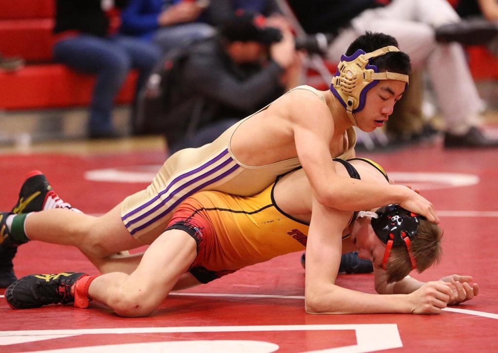 Oak Harbor&rsquo;s Jakob Dailey, top, tangles with Tanner Laurzon of Marysville-Pilchuck in the bout for third and fourth places. Laurzon eventually won the match with a fall. (Photo by John Fisken)