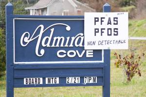 A sign mounted to an entrance sign to Admiral&rsquo;s Cove reveals good news Friday, March 3, 2017 for residents awaiting test results from water samples taken from their community wells last month: No contaminants were detected. Photo by Ron Newberry/Whidbey News-Times