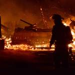 A firefighter is silhouetted against the burning remains of the historic Smith Barn on Ebey&rsquo;s Prairie. Photo by Megan Hansen/Whidbey News-Times.