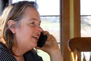 Georgie Smith, Coupeville fourth-generation farmer, speaks to an employee with Skagit Farmers Supply about a soil test that was supposed to be conducted on her farm Wednesday. From her kitchen window, Smith can see the debris pile that remains of the family&rsquo;s historic barn that burned down Monday night. Photo by Ron Newberry/Whidbey News-Times