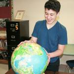Zachary Badaouie examines a globe during his history class at Oak Harbor Middle School. He is currently in preparation for the state geography bee. Photo by Daniel Warn/Whidbey News-Times