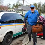 At a shift change in Coupeville, Island Transit driver Otis Jenkins hustles to start his afternoon duty as driver Tito Gutierrez ends his day. Photo by Patricia Guthrie/Whidbey News-Times