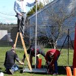 Cody Staker and other volunteers help set up the finish line camera and timing system. (Photo by John Fisken)