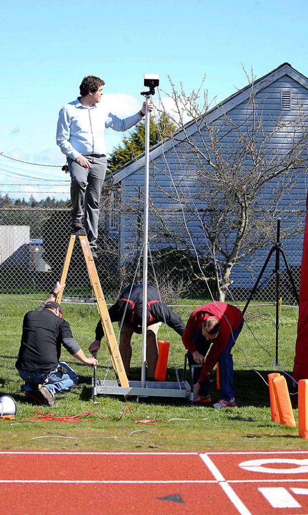 Cody Staker and other volunteers help set up the finish line camera and timing system. (Photo by John Fisken)