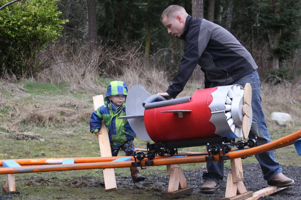 Scott Brazelton and his 3-year-old son Wyatt get the roller coaster cart in position to launch at their property in Oak Harbor Wednesday, March 1, 2017. Brazelton, a Navy pilot, built a roller coaster from scratch for his son. Photo by Ron Newberry/Whidbey News-Times
