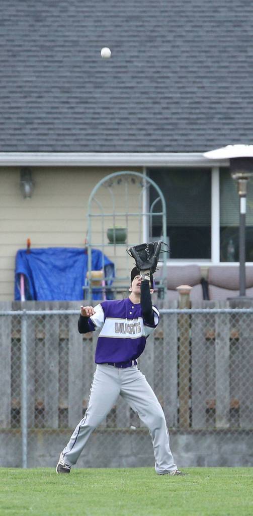 Oak Harbor left fielder Caleb Fitzgerald looks in a fly ball Friday. (Photo by John Fisken)