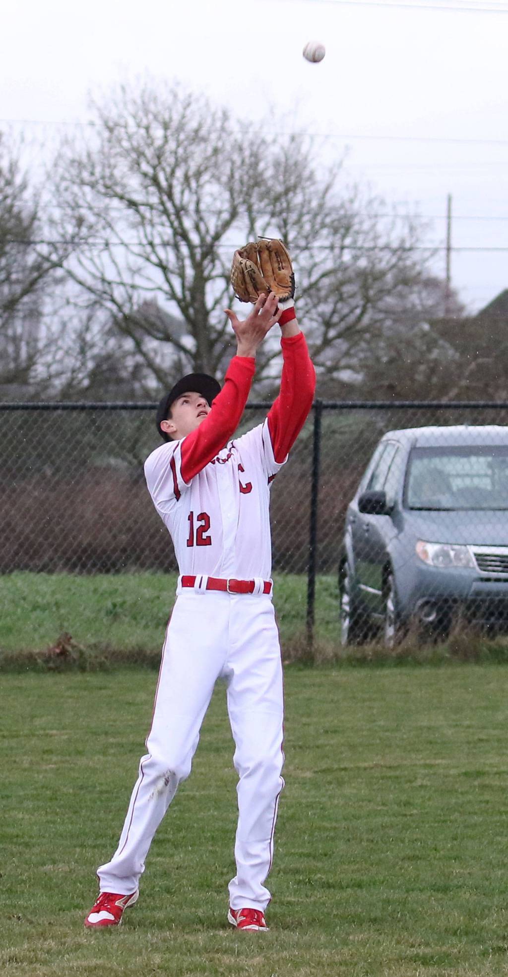 Joey Lippo settles under a Sequim fly ball. (Photo by John Fisken)