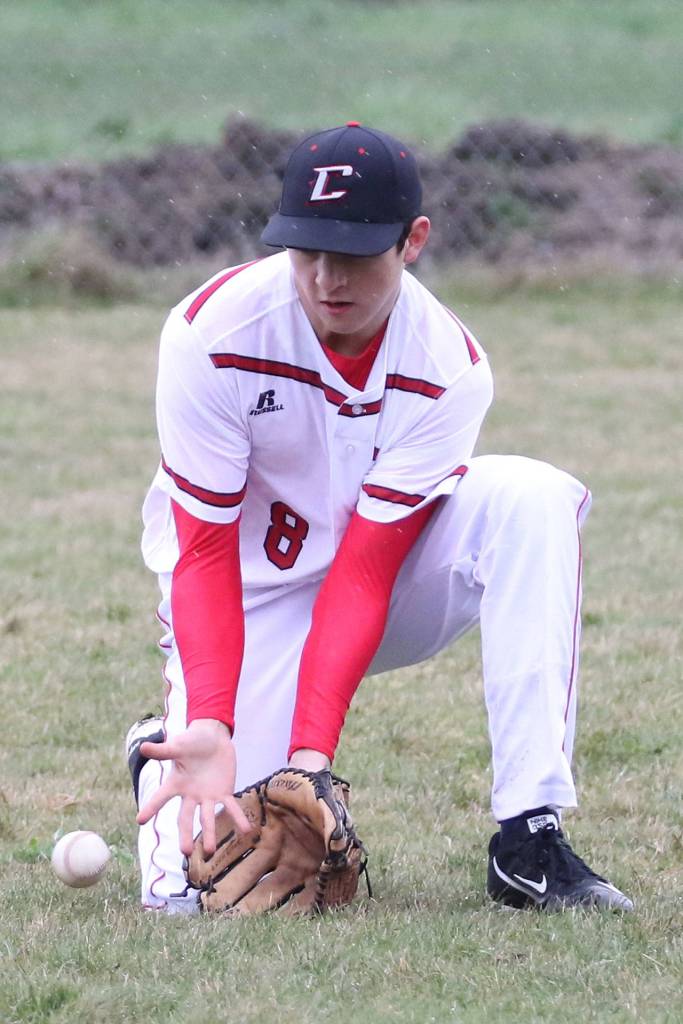 Outfielder Ethan Marx scoops out a ground ball against Sequim. (Photo by John Fisken)