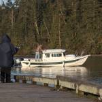 An angler jigs for smelt on the fishing pier while a boater returns to the boat launch at Cornet Bay on Feb. 13, 2017. The fishing pier will be replaced this summer. Photo by Ron Newberry/Whidbey News-Times
