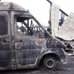 A Central Whidbey Fire & Rescue firefighter puts water on hot spots on March 7, the morning after the Smith barn fire in Coupeville. The delivery van was destroyed among the debris. The van was parked near the office where fire investigators believe the fire started. Photo by Ron Newberry/Whidbey News-Times