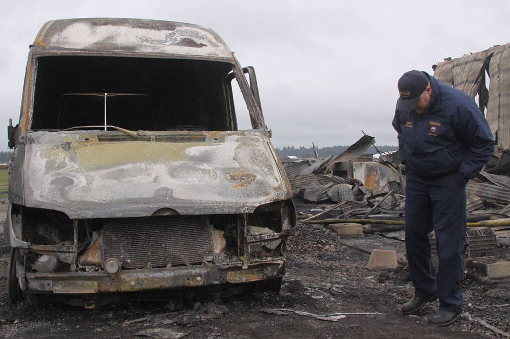 Charlie Smith, deputy fire chief with Central Whidbey Fire & Rescue, examines a delivery van Tuesday morning that was destroyed in Monday night&rsquo;s fire that took down the historic Smith Barn at Willowood Farm in Coupeville. The fire occurred at 8 p.m. Monday night. Photo by Ron Newberry/Whidbey News-Times