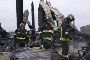 Firefighters with Central Whidbey Fire & Rescue look for hot spots Tuesday morning at Willowood Farm on Central Whidbey. A fire Monday night destroyed the historic Smith Barn. As of Tuesday morning, a cause had not been determined. Photo by Ron Newberry/Whidbey News-Times