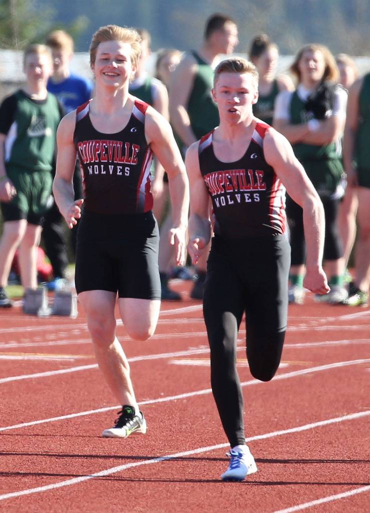 Kyle Burnett, left, and Jacob Smith head to the finish line in the 100. (Photo by John Fisken)