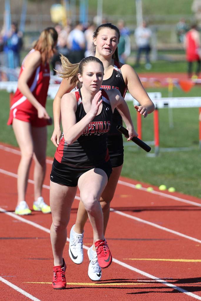 Lauren Grove takes the handoff from Lindsey Roberts in the 4x200 relay. (Photo by John Fisken)