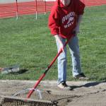 Jesse Hester rakes up the triple jump pit. (Photo by Jim Waller/Whidbey News-Times)