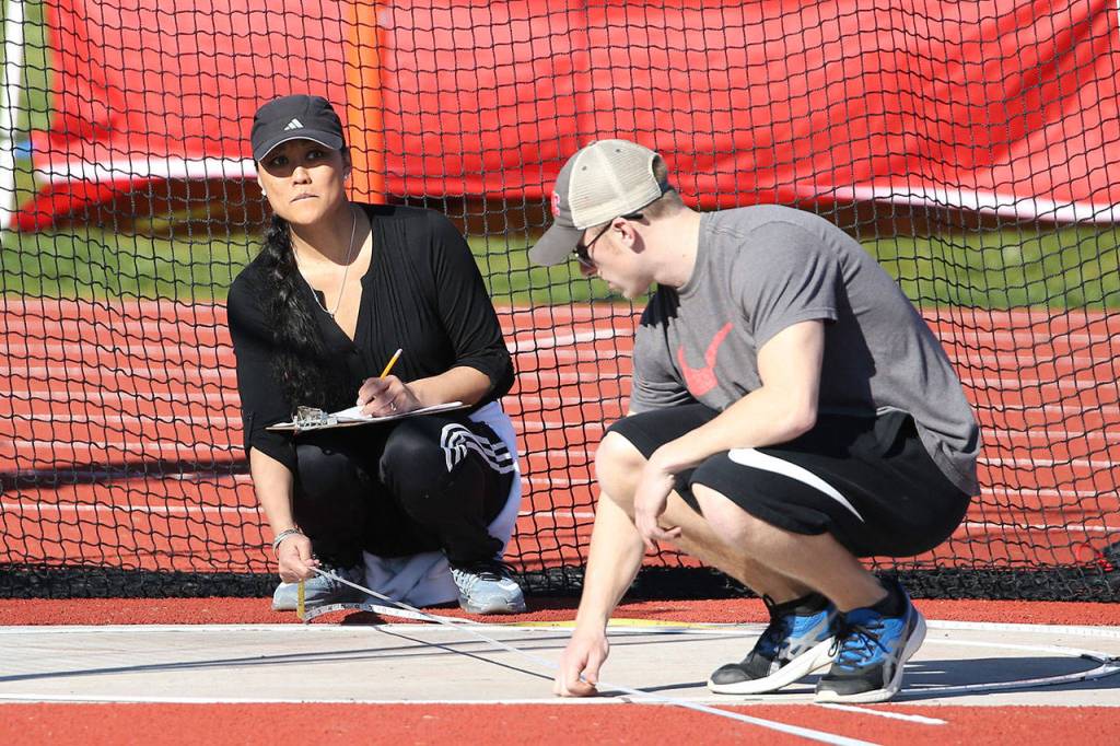 Eileen Stone, left, and Dalton Martin help with the discus competition. (Photo by John Fisken)