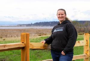 Jessica Larson, a land steward with the Whidbey Camano Land Trust, stands before a split-rail fence Thursday, Aprl 6, 2018 that was installed in March to keep duck hunters and others from parking on the property near Crockett Lake in Central Whidbey. The land trust purchased the 85-acre property from a private landowner in December on the lake&rsquo;s northeast corner to protect it and its abundant species of birds as part of the 423-acre Crockett Lake Wetland Preserve. The newly acquired property had been a widely used access point and place to park for waterfowl hunters for years. Photo by Ron Newberry/Whidbey News-Times