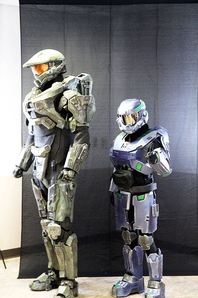Coming in at 6 feet 11 inches, John Groves, left, is almost as tall as the character he cosplayed Saturday at Oak Harbor&rsquo;s first comicon, hosted by Oak Harbor Library. Once Groves donned the Master Chief&rsquo;s iconic armor, the world&rsquo;s most accurate to date, he was elevated to a towering 7 feet 11 inches. At right, Dustin Allen represented Bothell in a Seahawks Master Chief costume. Photo by Daniel Warn/Whidbey News-Times