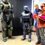 Katrina Daggett, Supergirl, held by Steve Daggett, admires Dustin Allen&rsquo;s Seahawks Master Chief armor at Oak Harbor Comicon Saturday at Oak Harbor Library. At left, Clinton resident John Groves fills out the world&rsquo;s most accurate Master Chief Armor from the Halo video game franchise. Photo by Daniel Warn/Whidbey News-Times