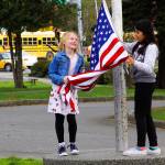 Coupeville Elementary School fifth graders May Crain, left, and Desi Ramirez-Vasquez take down the flag at the end of the school day March 31, 2017. The Coupeville School District is exploring options as it looks at long-range planning for the aging elementary school. One option is to build a new school away from the busy highway. Photo by Ron Newberry/Whidbey News-Times