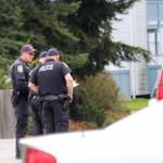 Oak Harbor police discuss an incident Wednesday in which streets were closed down and homes evacuated because of concern that a potentially armed man may have bee hold up in a house. (Photo by Jessie Stensland / Whidbey News-Times)