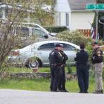 Oak Harbor police officers talk near the site of a standoff Wednesday. (Jessie Stensland / Whidbey News-Times)